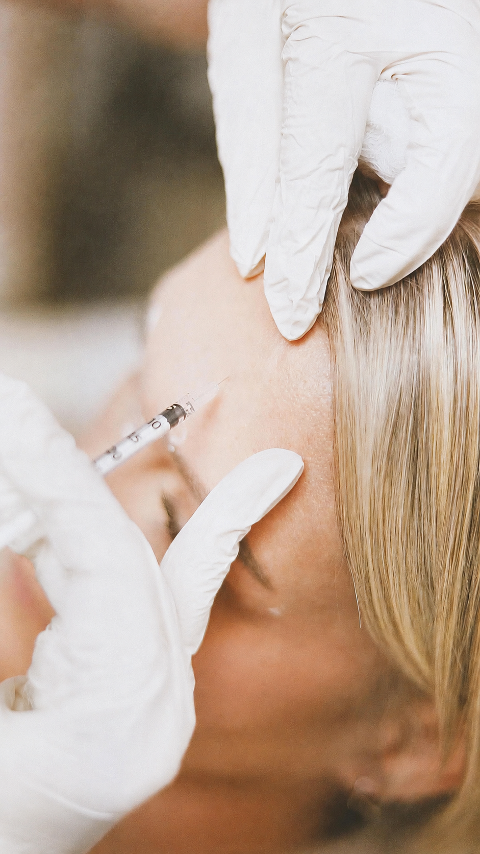 A healthcare professional administering a cosmetic injection to a woman's face, wearing white gloves.