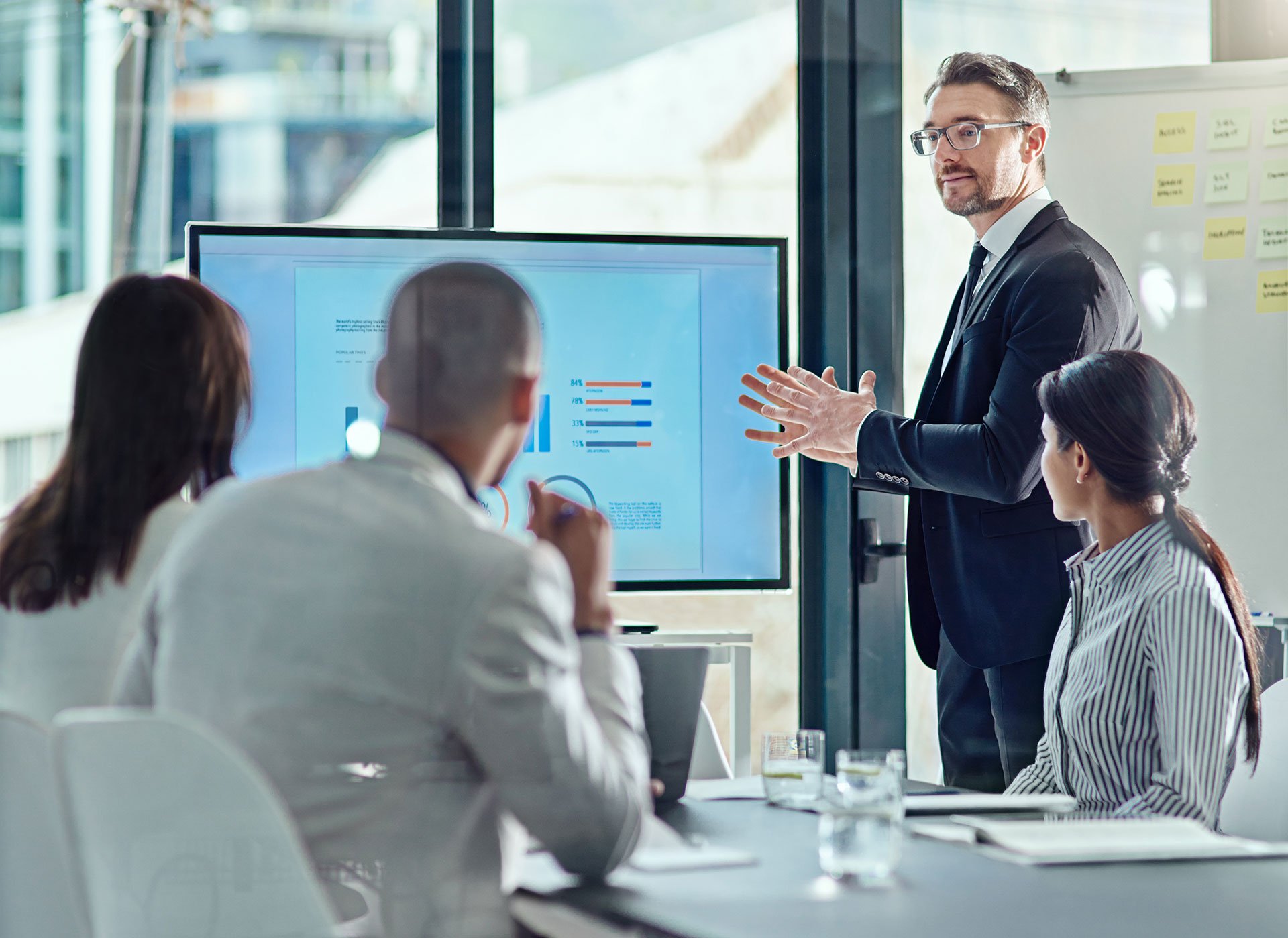 A consultant running a training session for three diverse individuals in a conference room.