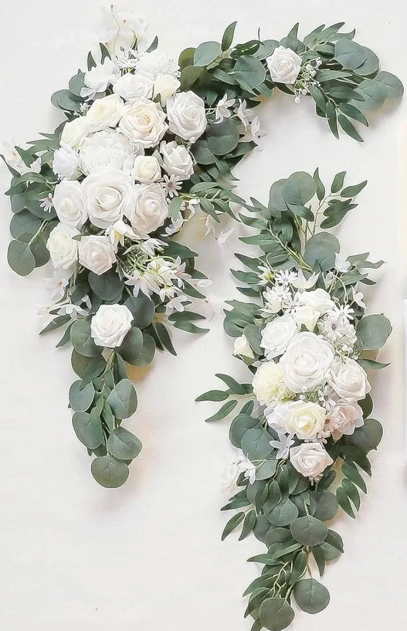 Letter 'P' made with white roses, daisies, and eucalyptus leaves.