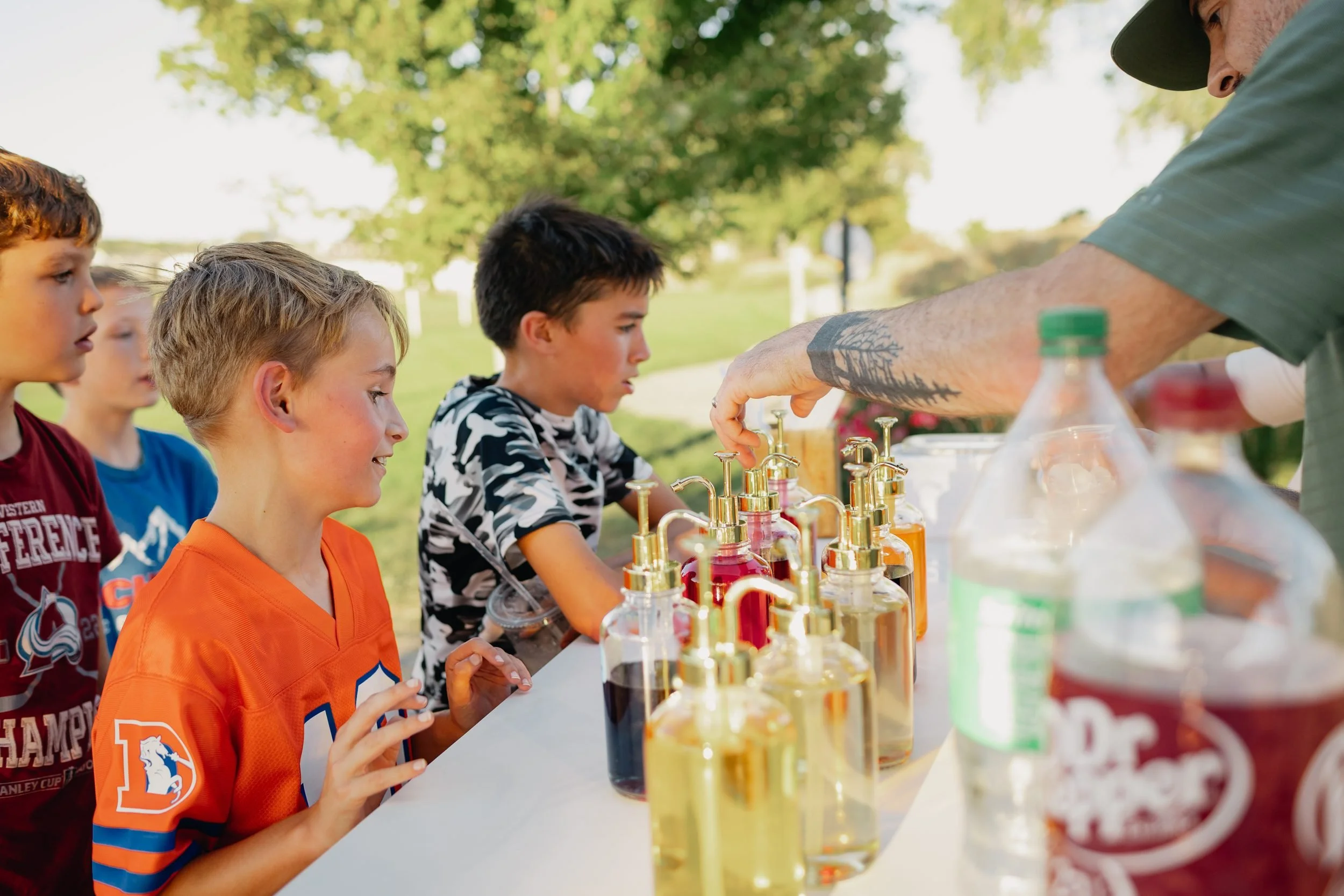 Excited kids choosing syrup flavors while a server builds their dirty sodas at a birthday party in Northern Colorado