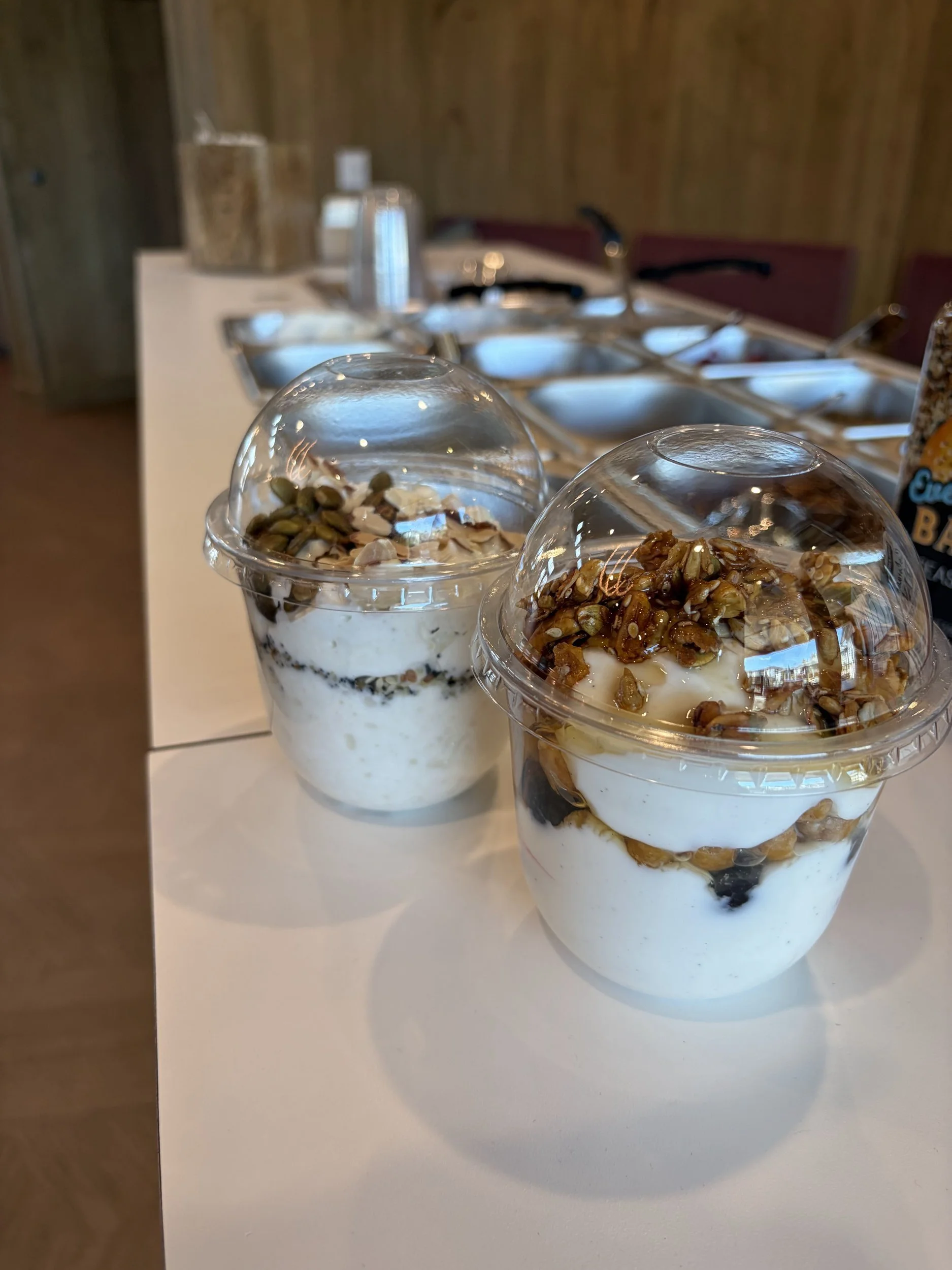 Two Greek yogurt parfait cups layered with berries, granola and nuts at Front Porch Social's Protein Power Bar in Northern Colorado