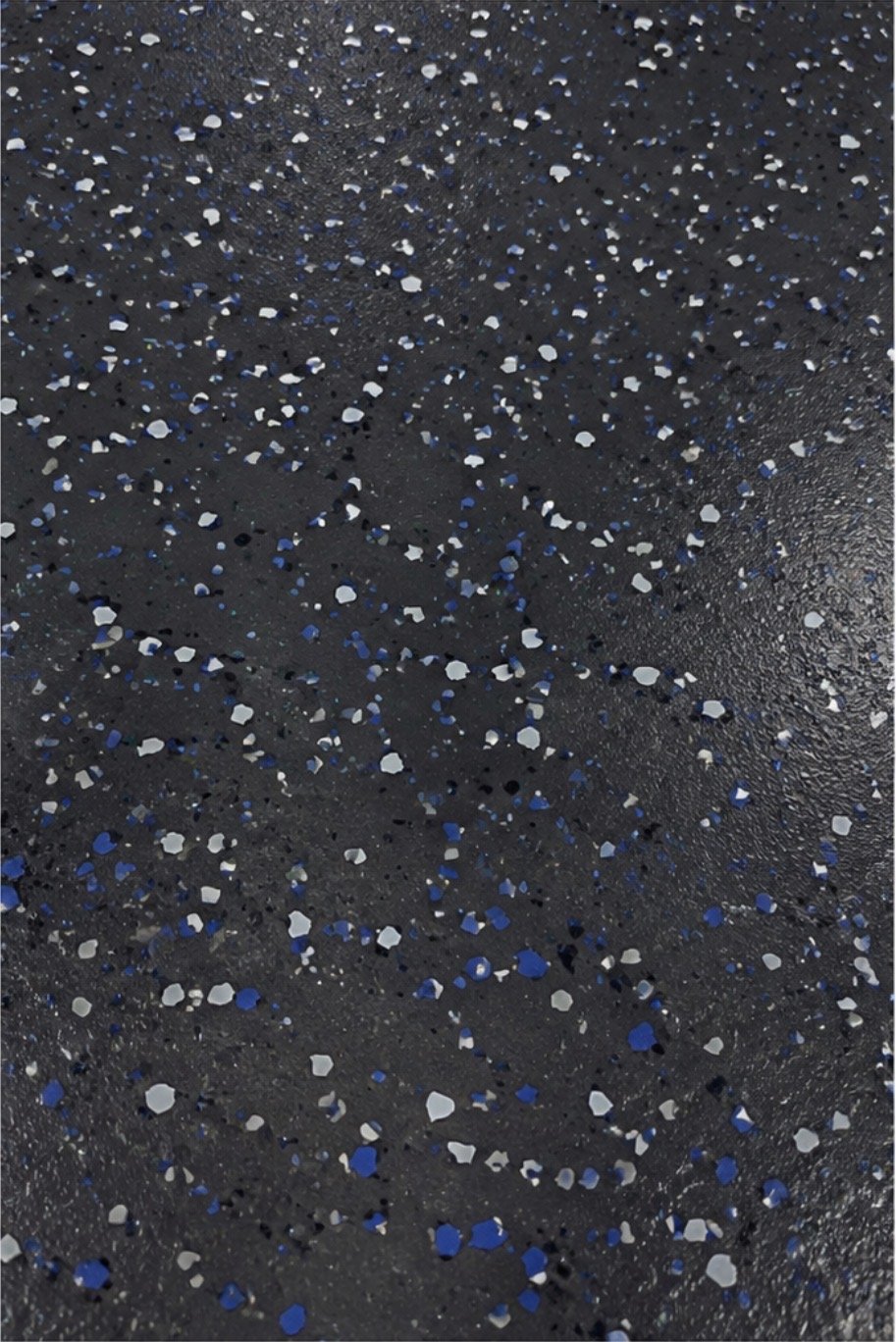 Close-up of a black, textured surface decorated with scattered silver and blue sequins.