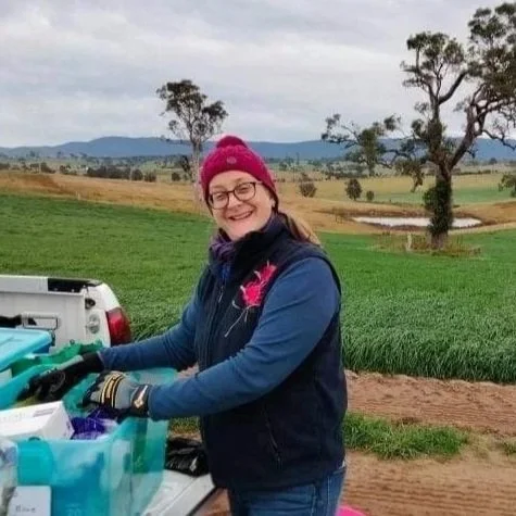 Image of auriol purdie A woman wearing glasses, a red knit hat, and a navy jacket with pink accents, smiling, her startup was helped by Beanstalk AgTech and Monsoon Ventures