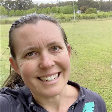 Image of Bec Hopper, resonAg, A woman outdoors in a grassy field, smiling at the camera with trees and a cloudy sky in the background , who was helped by Beanstalk AgTech and Monsoon Ventures