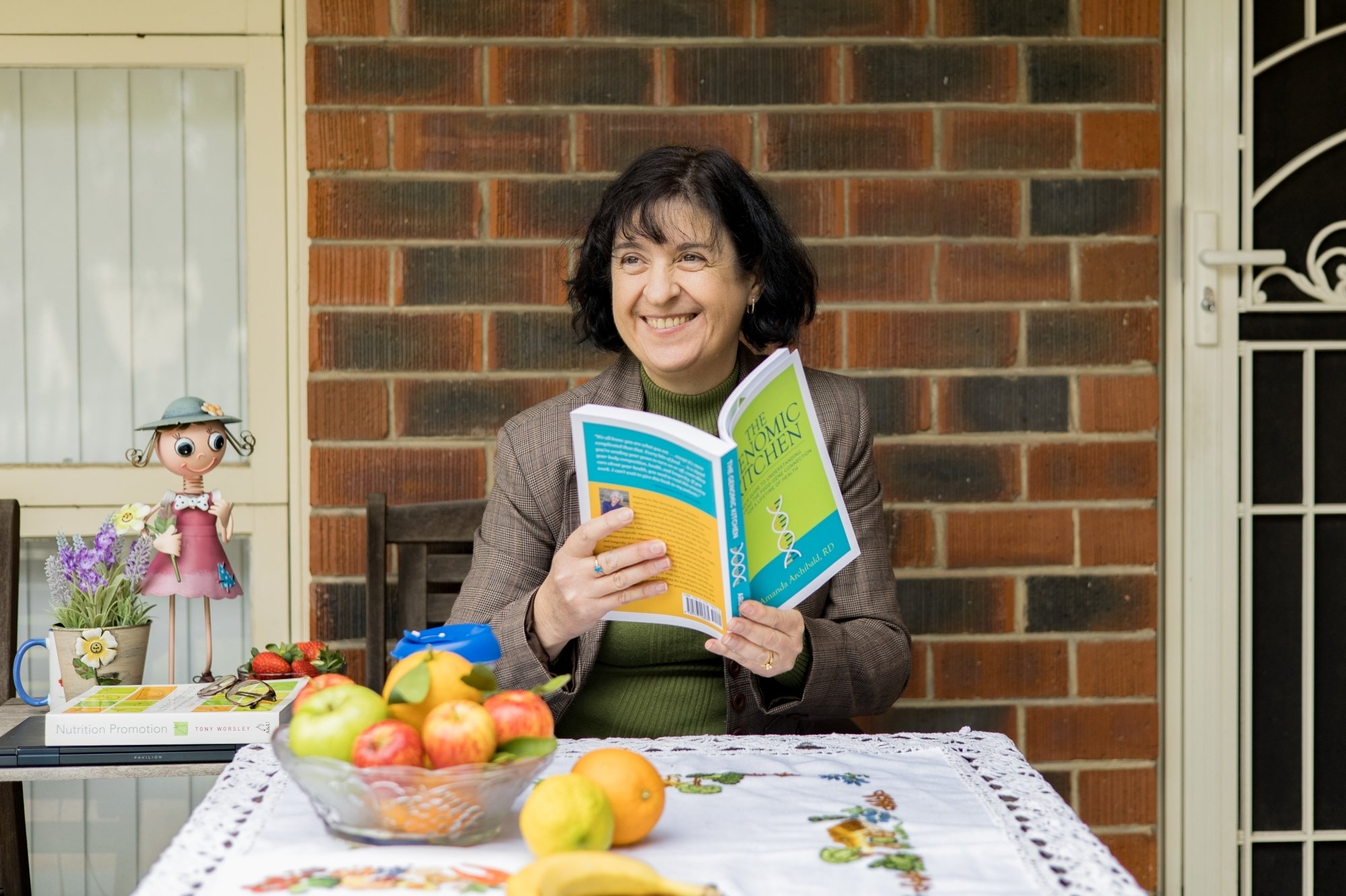 Portrait of Mechelle Palermo reading at a table outside