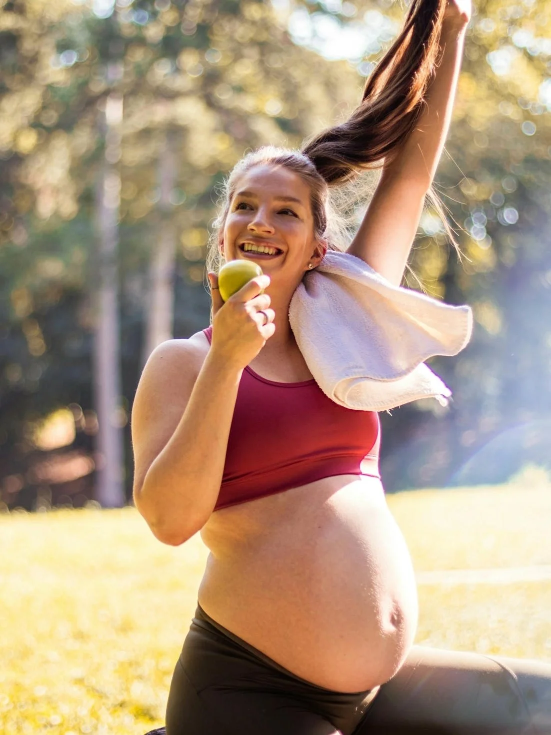 Pregnant woman eating an apple after exercise