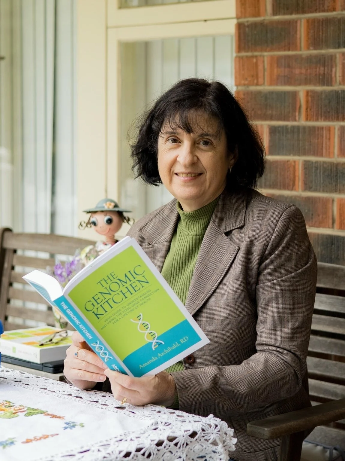Portrait of Mechelle Palermo reading The Genomic Kitchen book by Amanda Archibald