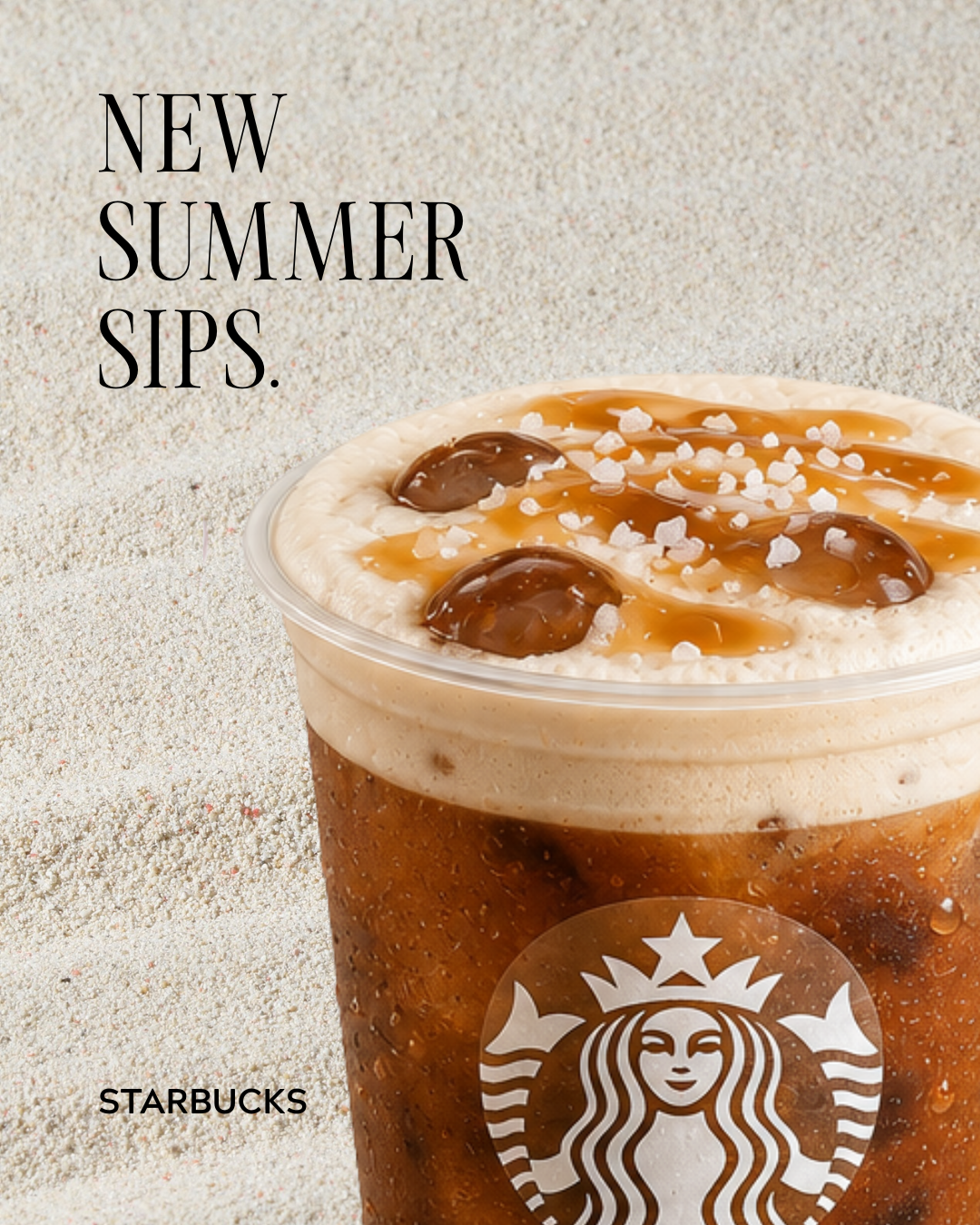 A Starbucks iced coffee beverage topped with whipped cream, caramel drizzle, and black pearls, served in a clear plastic cup on a sandy background with text saying 'New Summer Sips'.