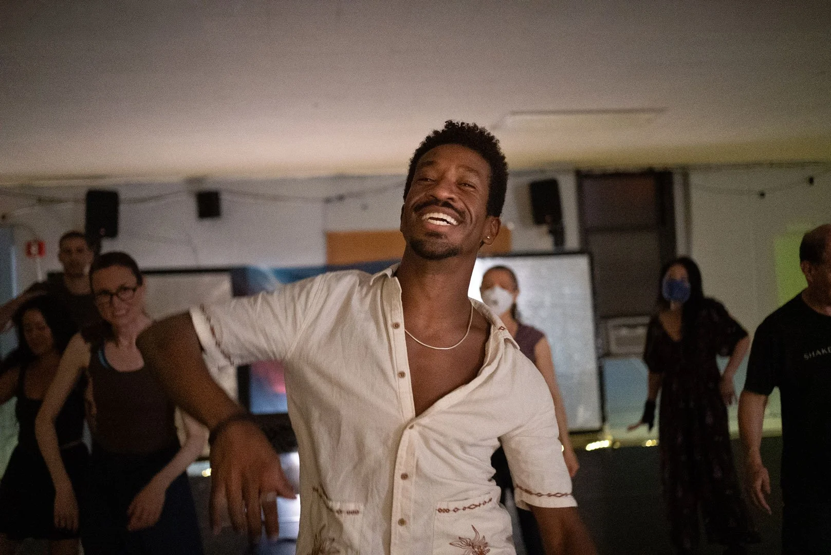 Smiling man dancing in a studio with a group of people