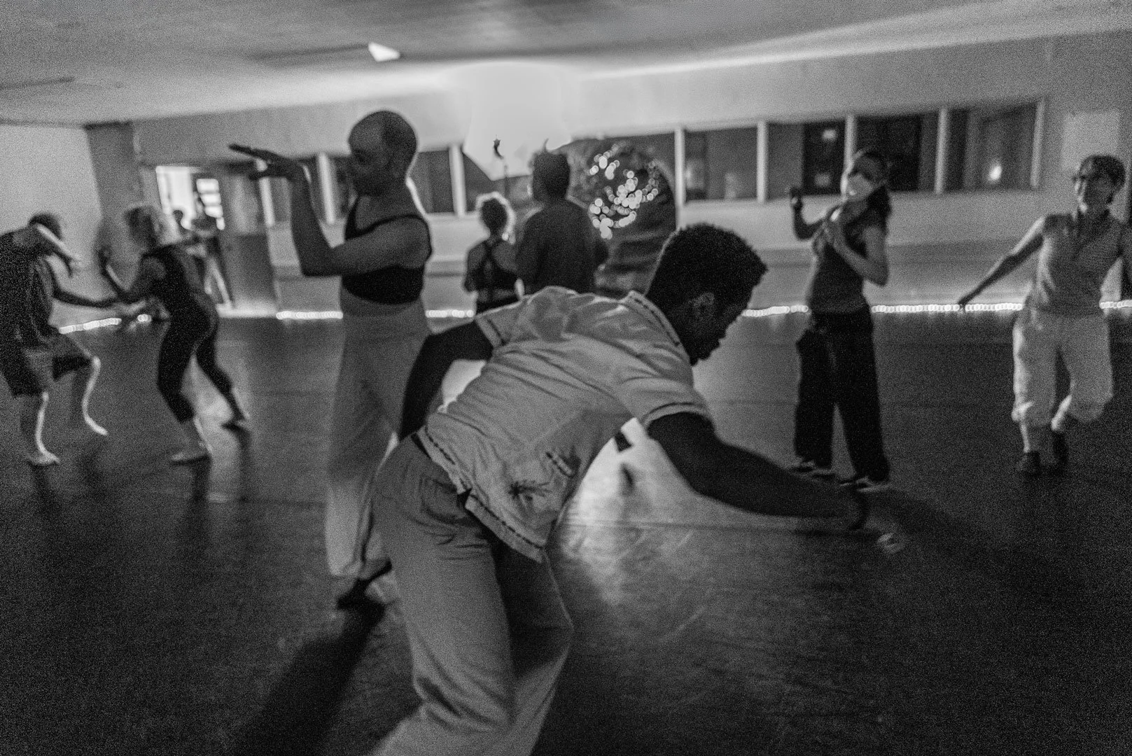 People dancing in a dimly lit studio during a group dance class