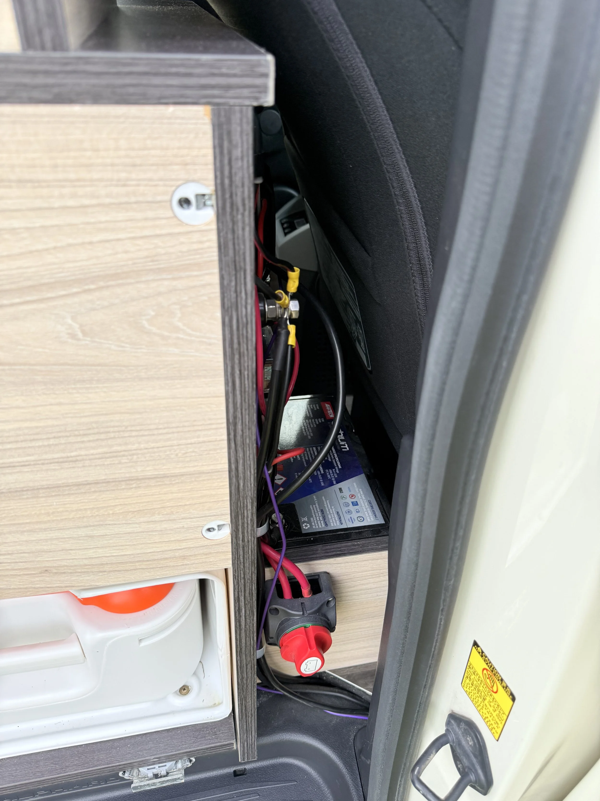 Electrical wiring and components inside a control panel cabinet, with wires connected to a circuit breaker and other device.