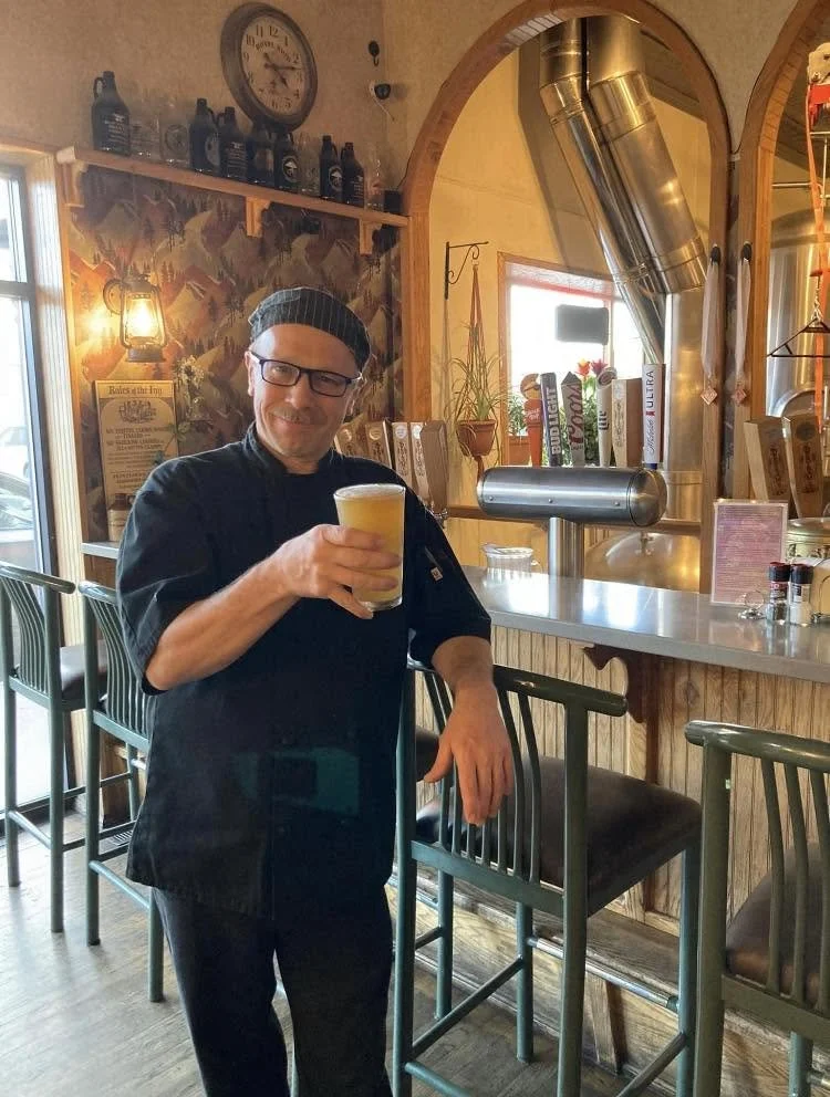 Chef Tony holding holding up a pint glass full of Bertram's beer. Cheers.