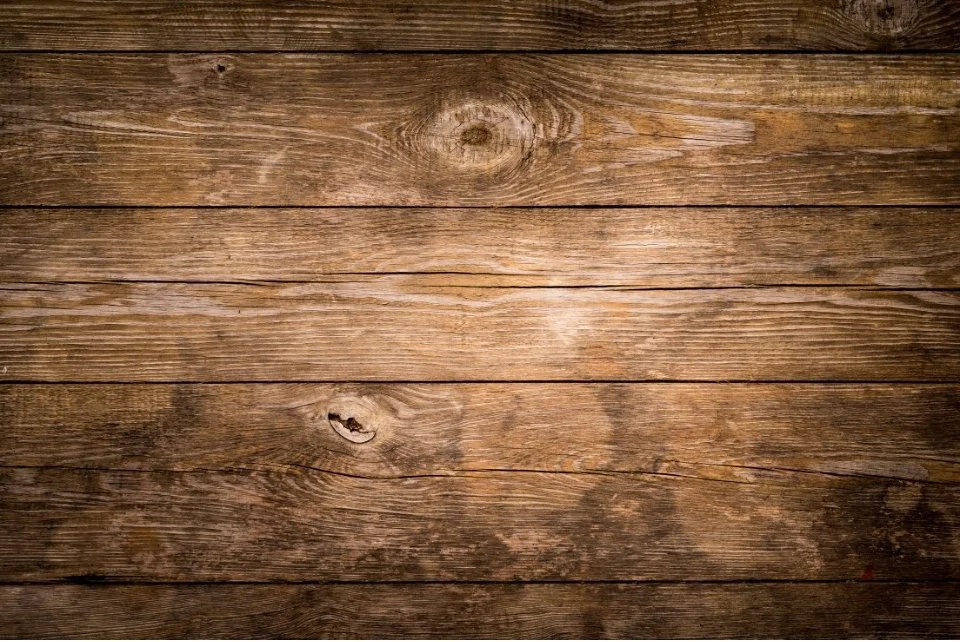 Close-up of a wooden surface with horizontal planks and visible wood grain.