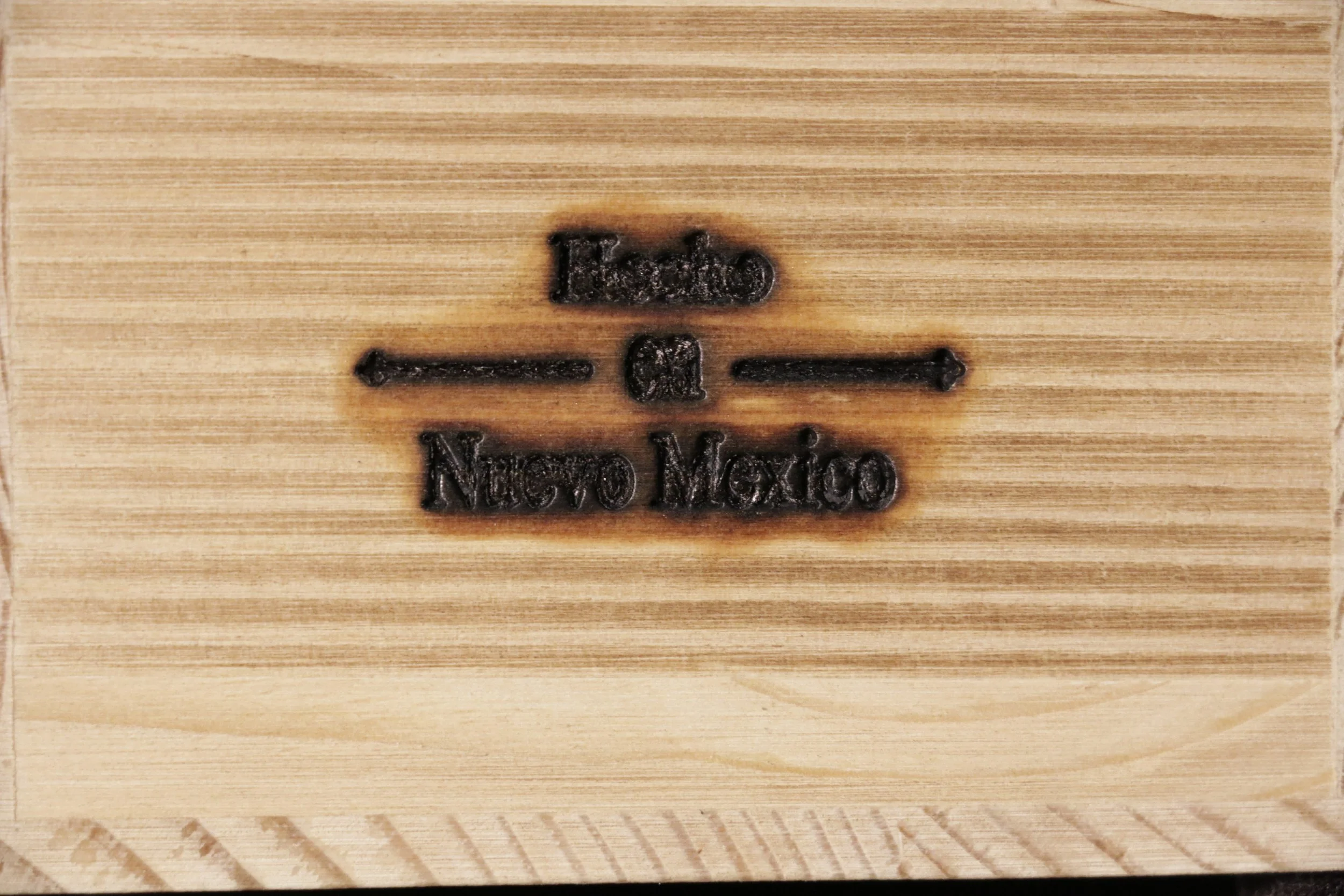 Close-up of a wooden surface with engraved text that reads 'Made in Mexico'.
