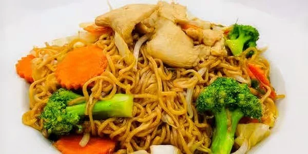 Plate of stir-fried noodles with chicken, broccoli, carrots, and other vegetables