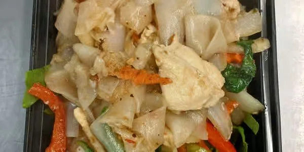 Mixed cooked vegetables including cauliflower, carrots, celery, and possibly green beans in a black container.