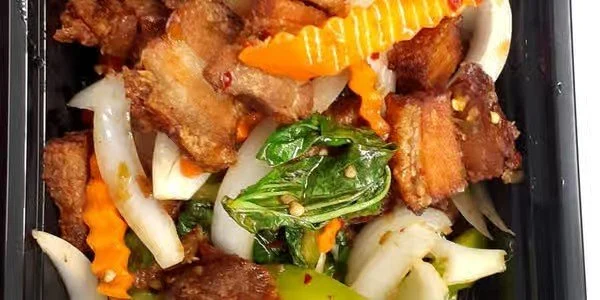 Fried pork belly with sautéed vegetables including bell peppers and cabbage.