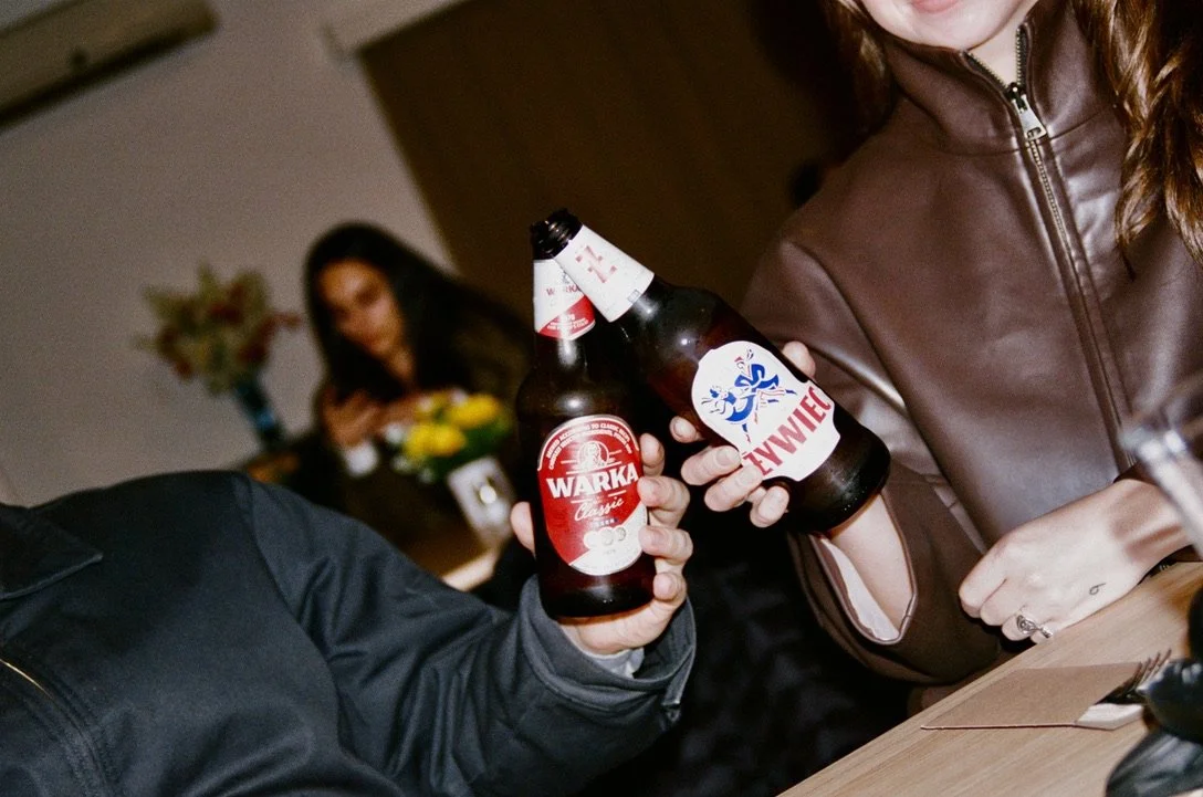 Guests raising bottles of Polish Warka and Żywiec beer at Dom Polski.