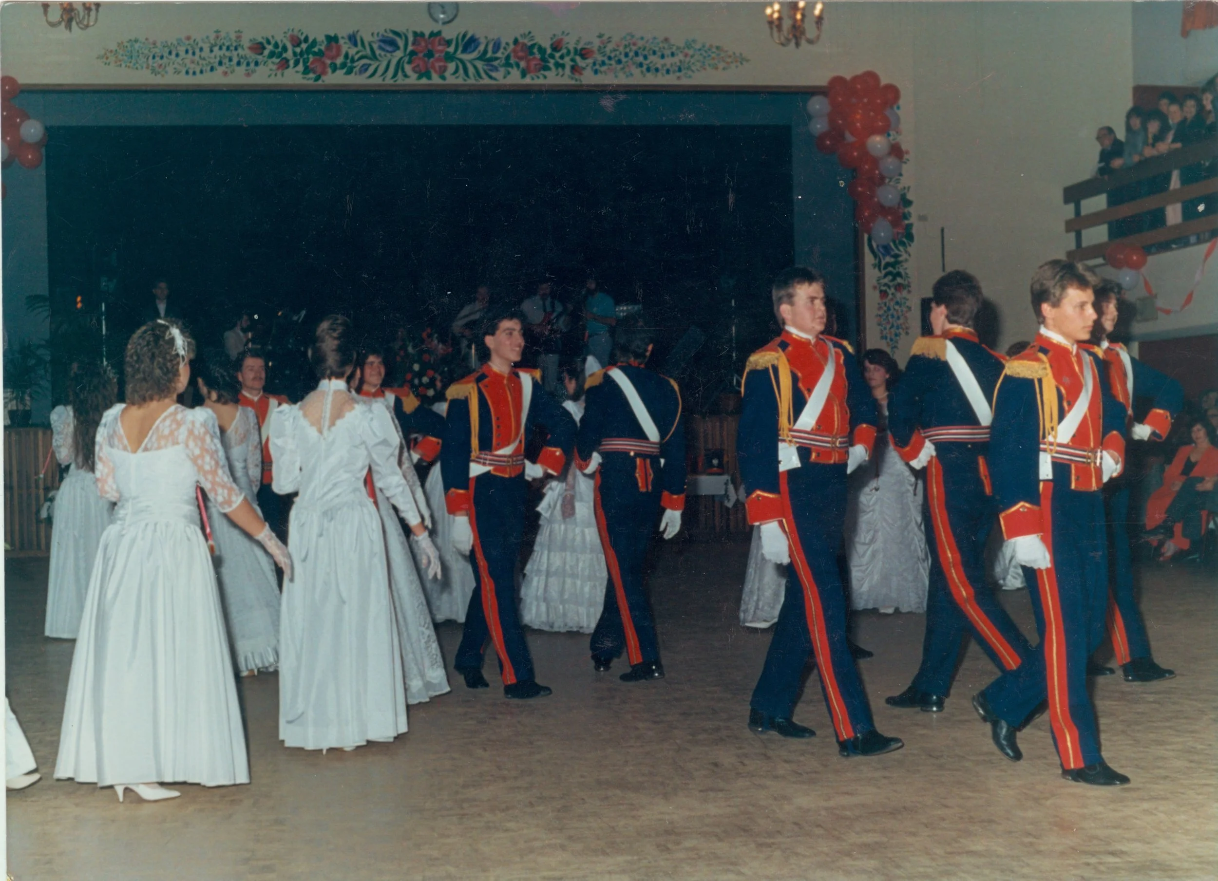 Polish folk dancers in red, blue and gold costumes dancing in a line at Dom Polski.