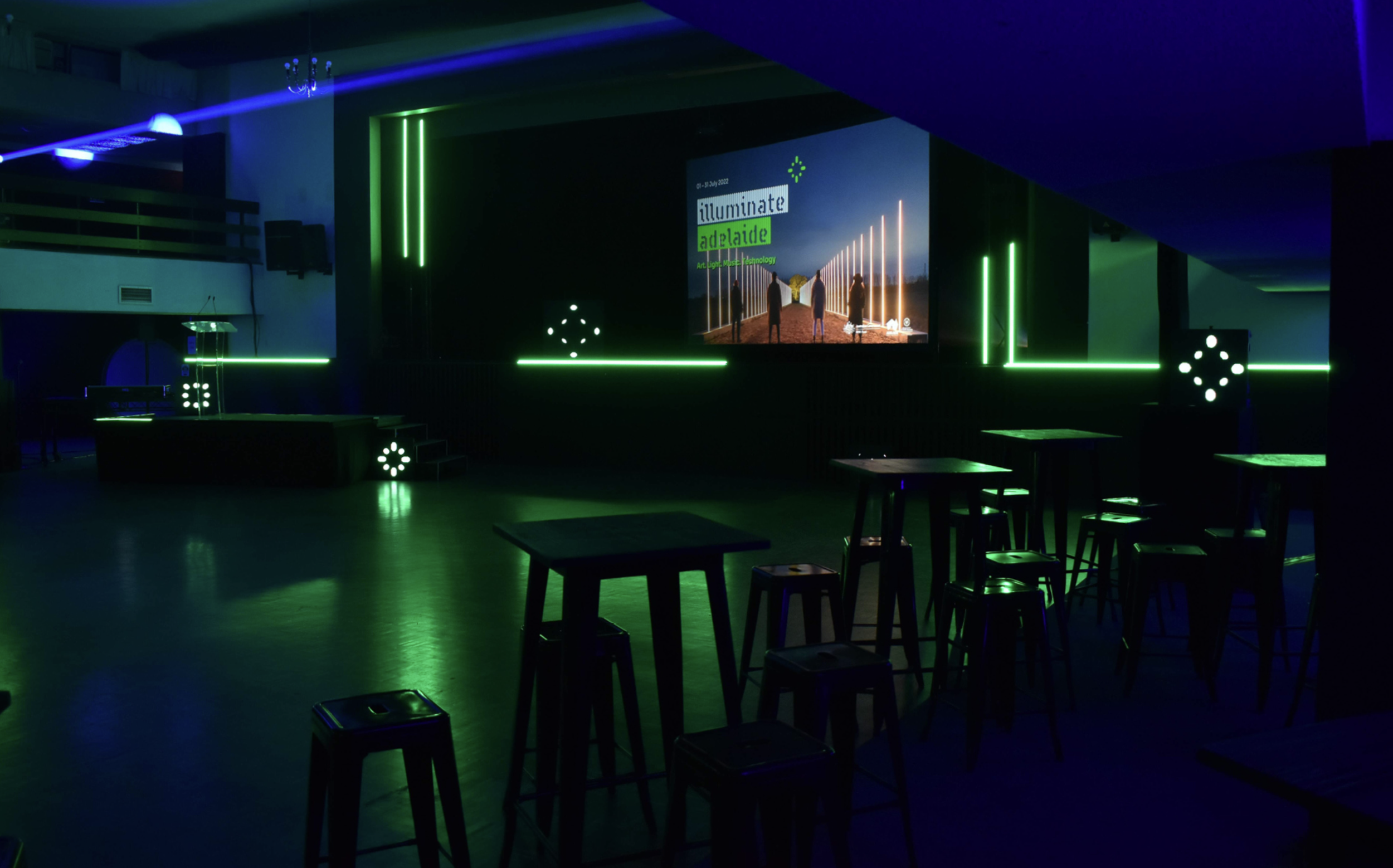 Dom Polski event space set up for Illuminate Adelaide, with green neon lighting.