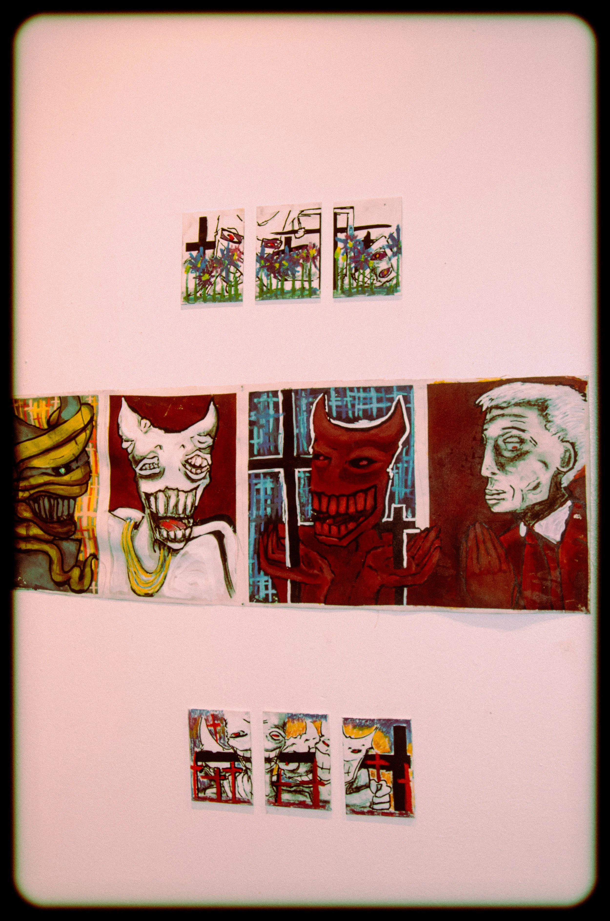 A collage of colorful artwork featuring cartoonish faces and abstract designs displayed on a pink wall.