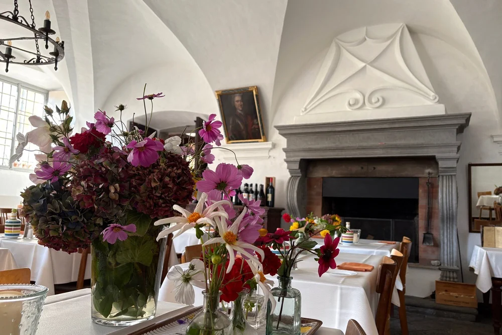 Der alte Saal im Palazzo Salis mit Kamin und Blumen auf den Tischen