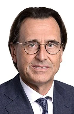 Nahaufnahme eines Mannes mit dunklen Haaren, Brille, Anzug und Krawatte, professionell aussehen.