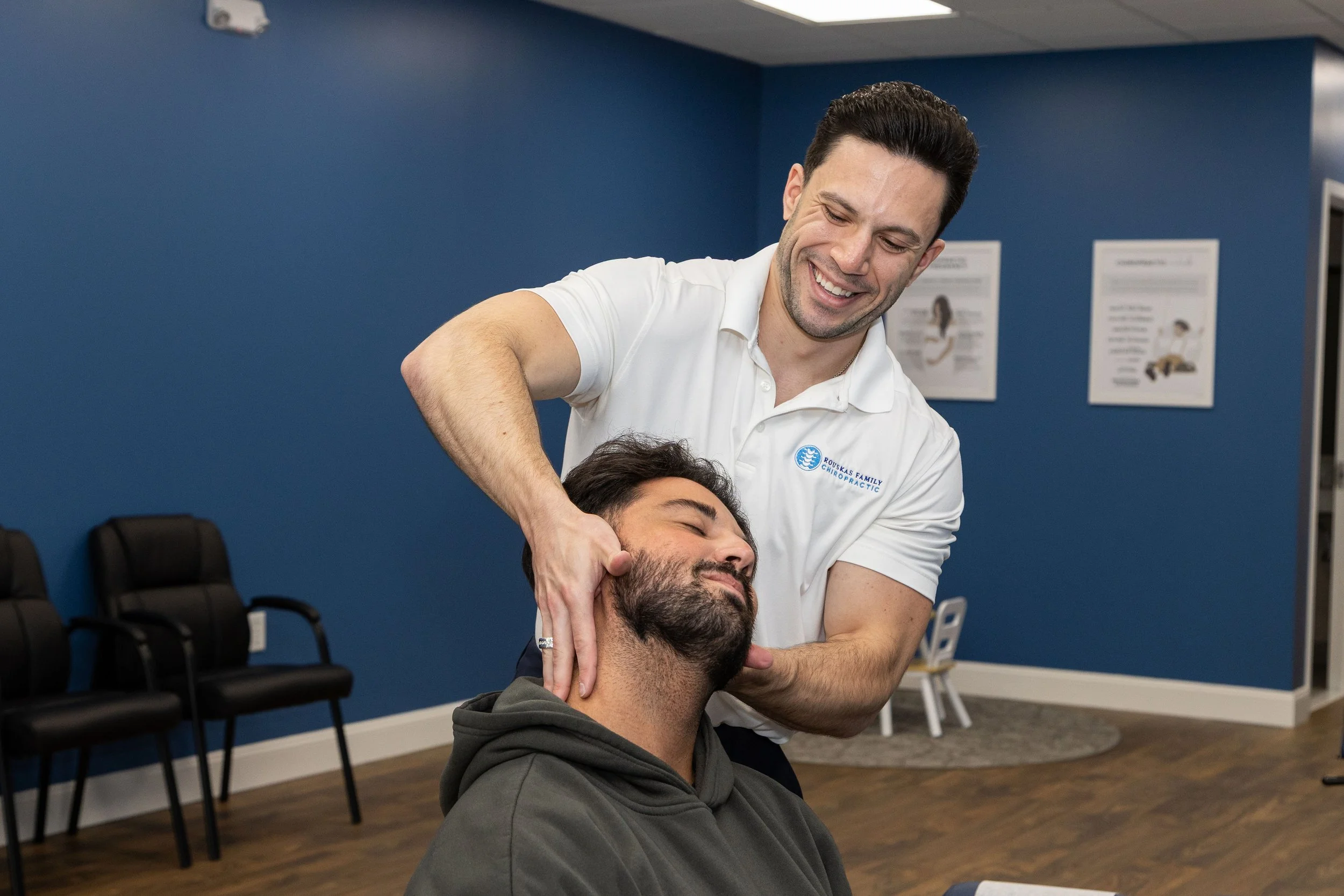 Dr. Mike Rouskas performs a gentle chiropractic neck adjustment during a personalized chiropractic treatment in Fairfield, NJ.
