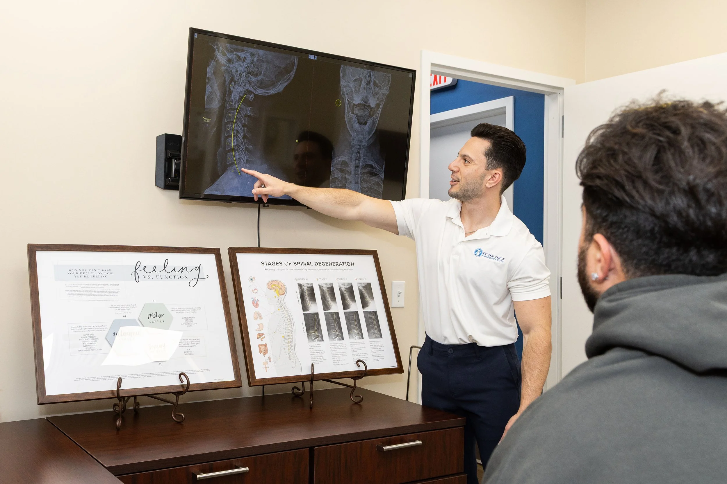 Dr. Mike Rouskas (chiropractor Fairfield NJ) reviews a patient's spine x ray chiropractic images during a consultation at his chiropractic practice in Fairfield, NJ.