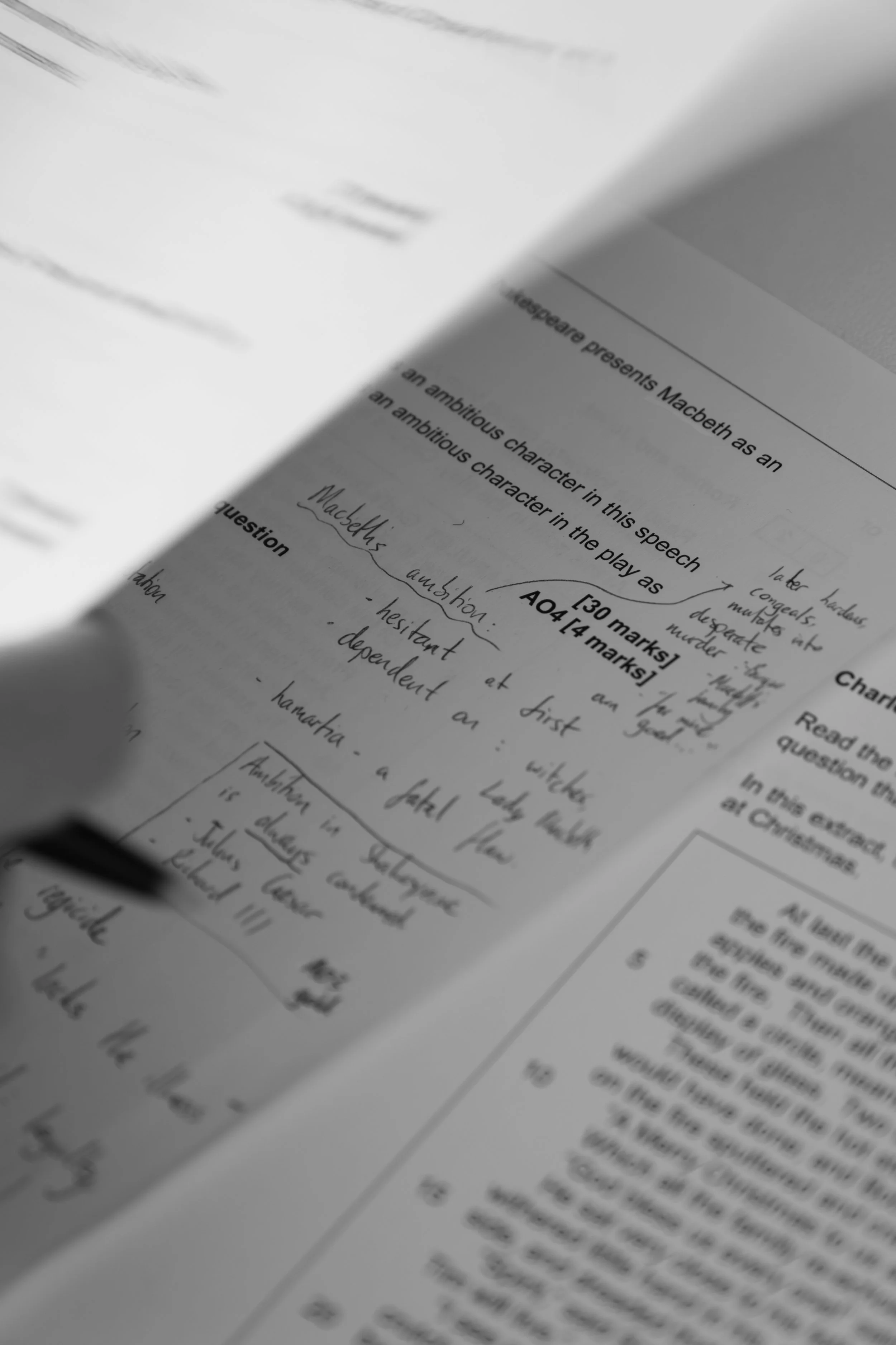 Close-up of a printed sheet of paper with handwritten notes and typed text, including references to Macbeth.