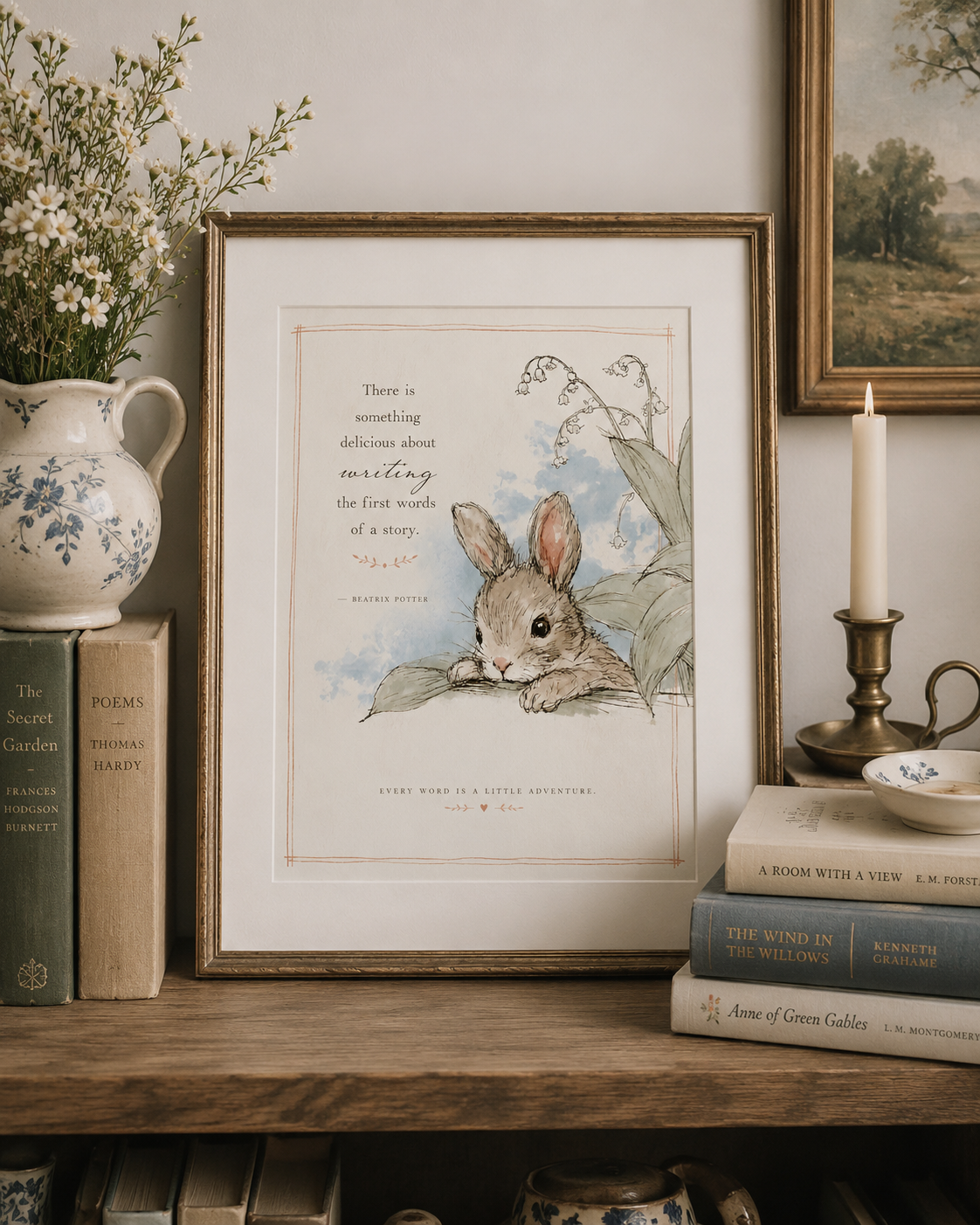 Framed watercolor illustration of a bunny with a quote by Beatrix Potter, decorative books, a ceramic vase with white flowers, a lit candle, and a landscape painting on a wooden shelf.