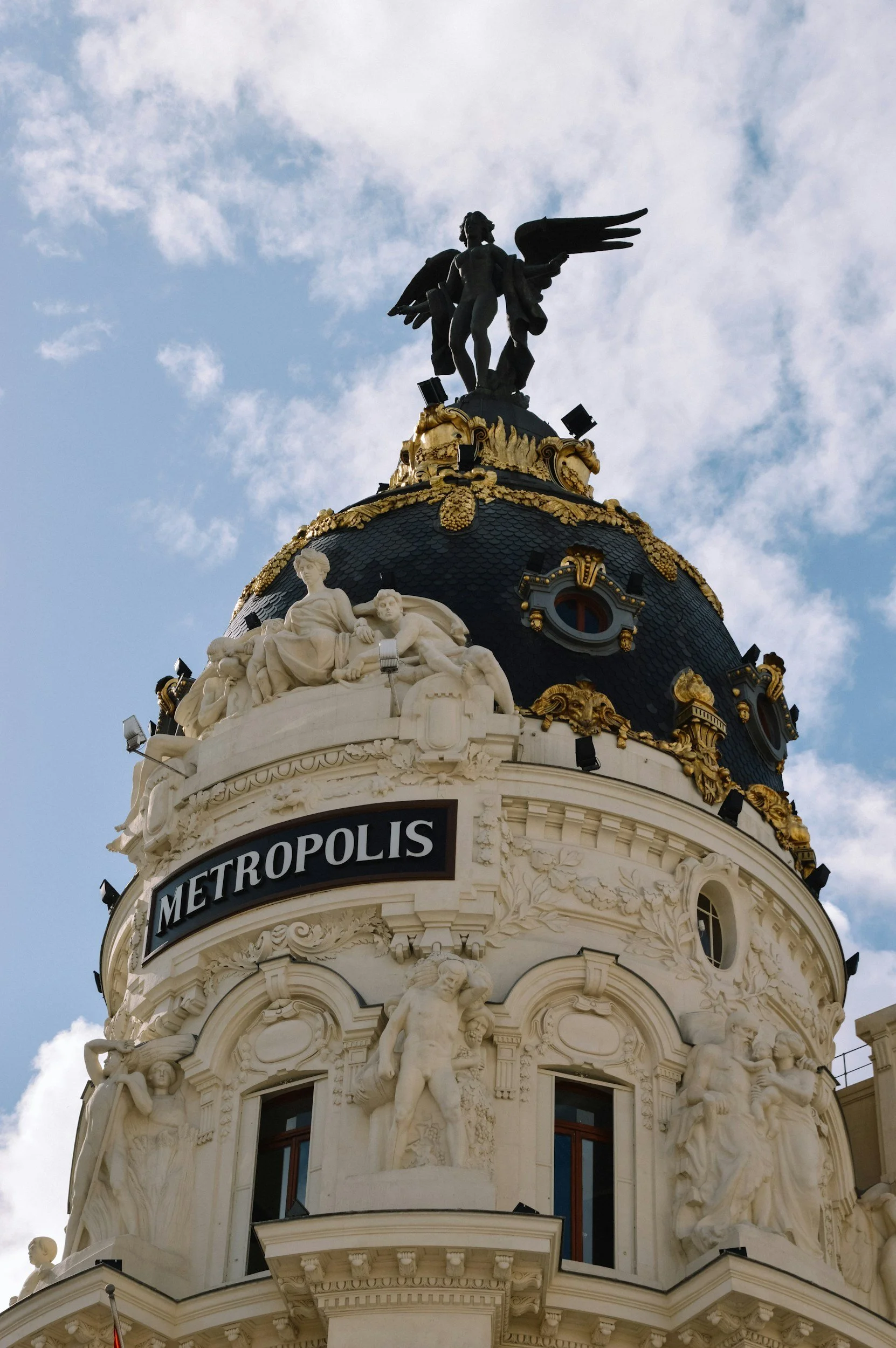 Metropolis Building in Madrid, Spain, with its ornate facade and iconic winged statue atop the dome