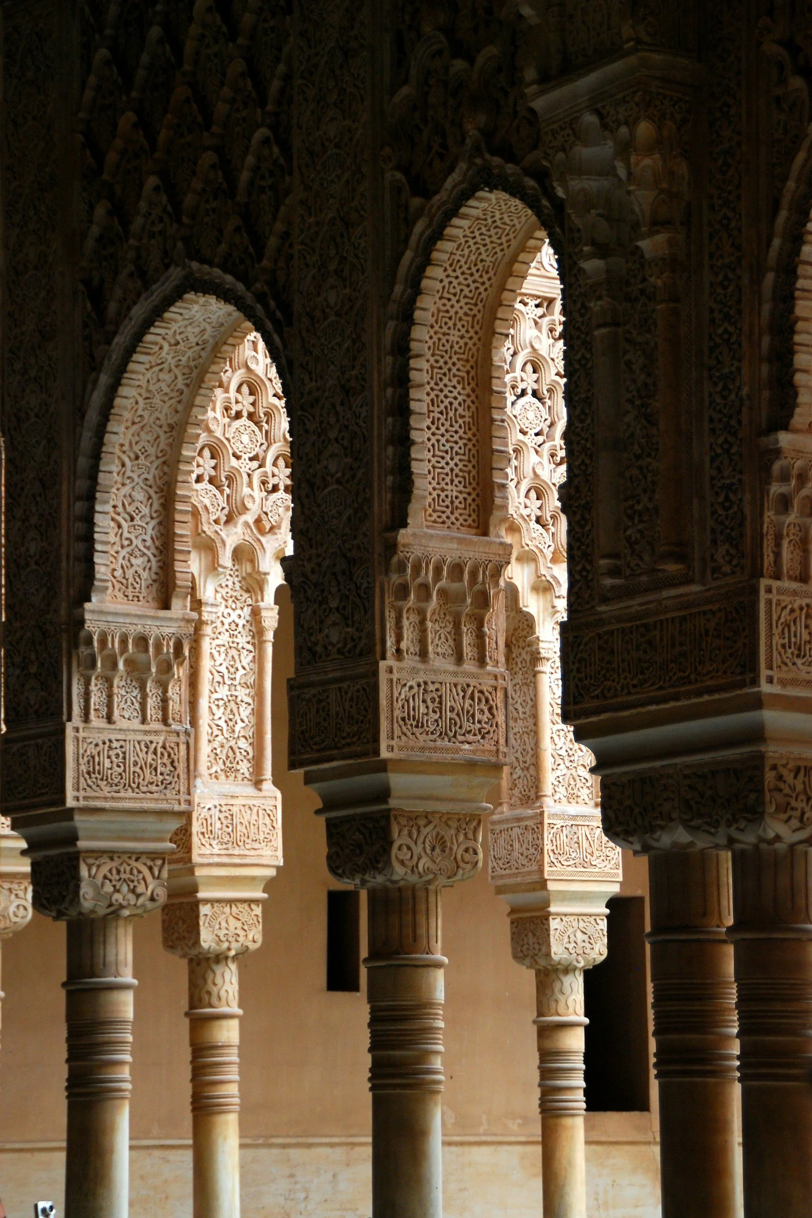 Intricate Moorish arches and geometric details inside the Alhambra in Granada, Spain