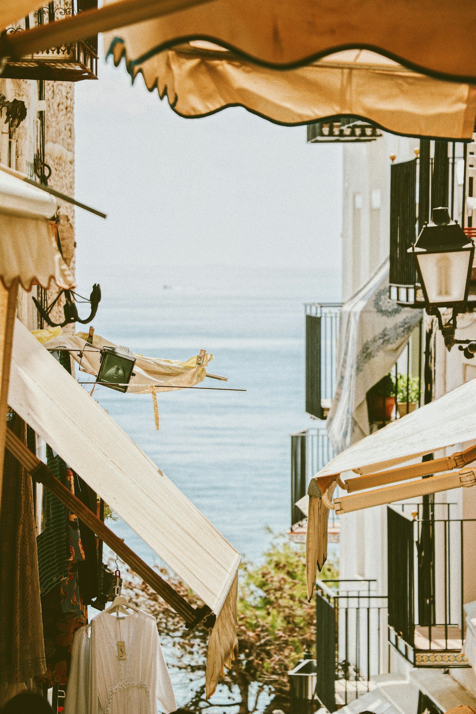 Charming coastal street with balconies overlooking the sea and tree-lined surroundings