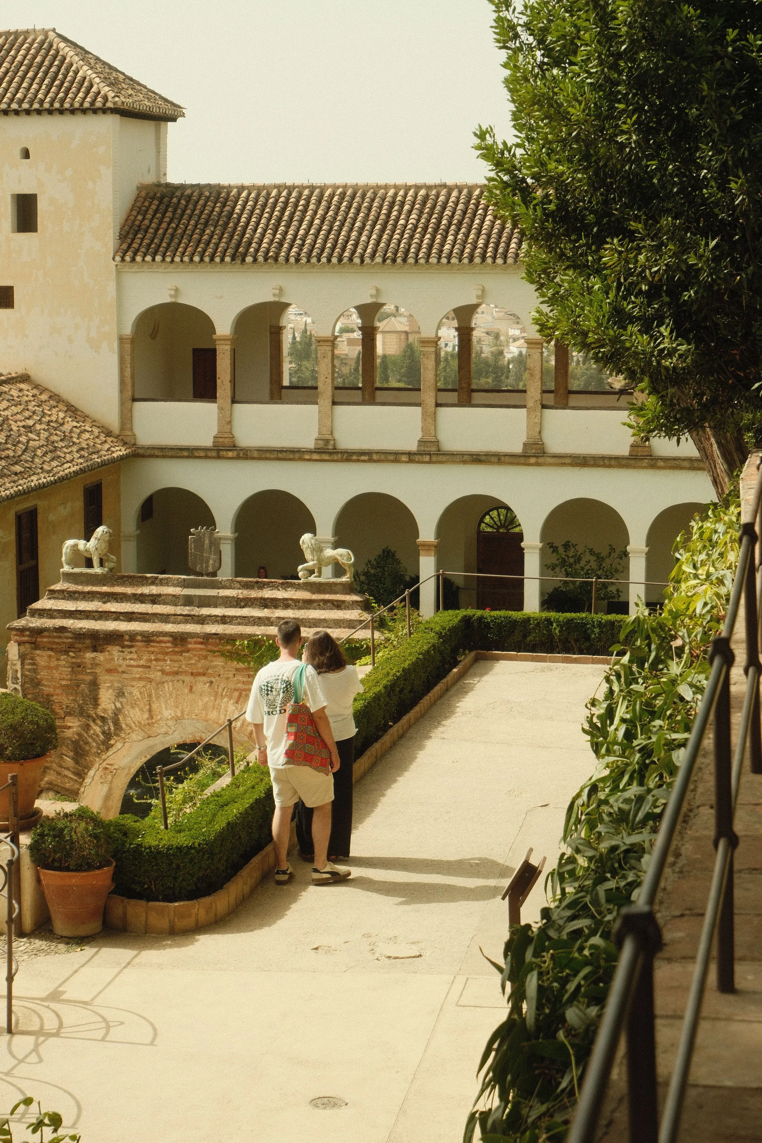 Couple exploring the Patio de la Sultana in the Generalife Gardens of the Alhambra, Granada.