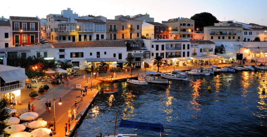 A waterfront scene at dusk at Ibiza's harbor, Spain.