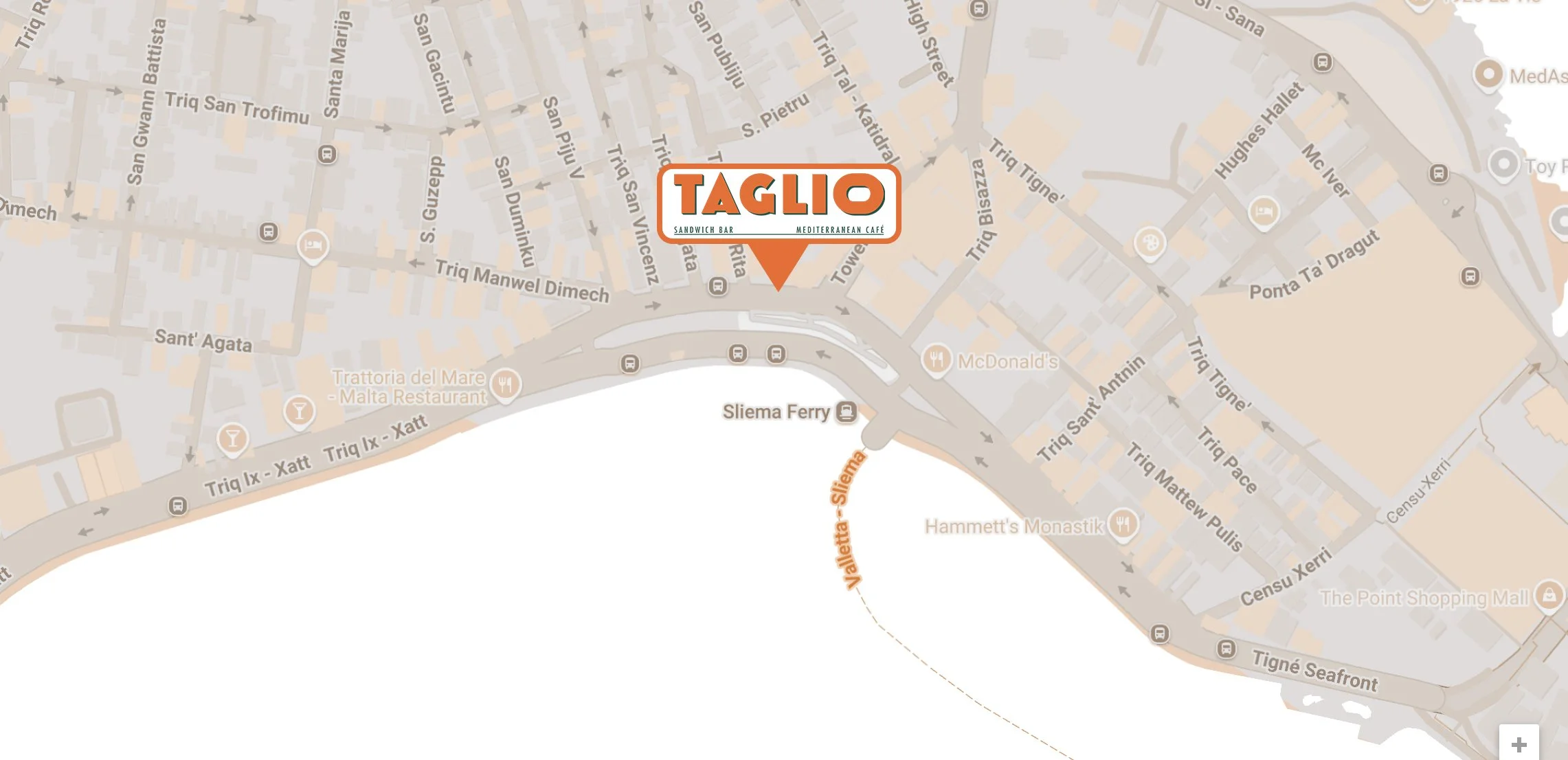 Map with a highlighted location marked as 'TAGLIO Sandwich Bar Mediterranean Cafe' in a city area near a ferry port, with street names in a foreign language and surrounding streets.