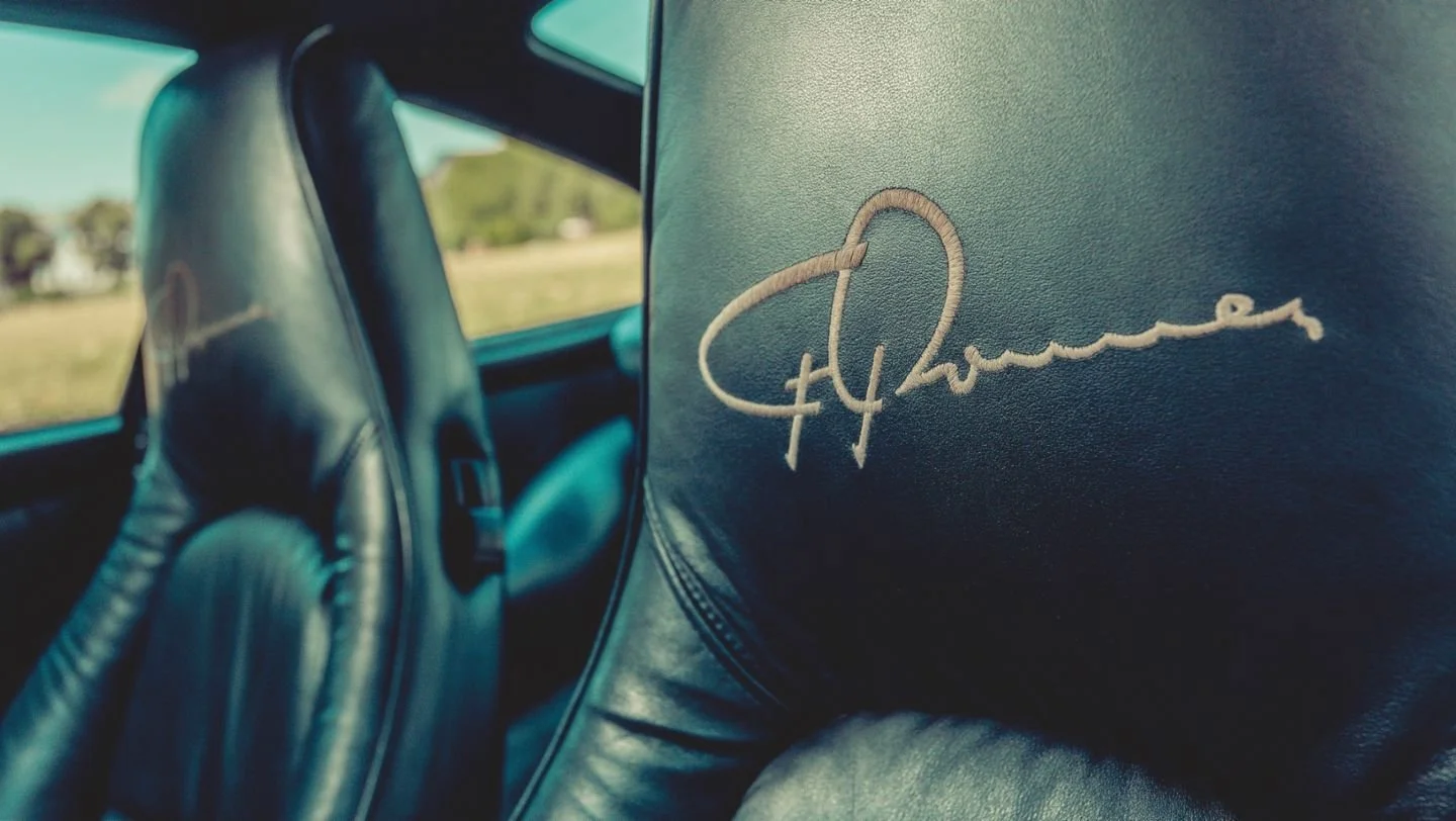 Close-up of a leather car seat with a signature embroidery.