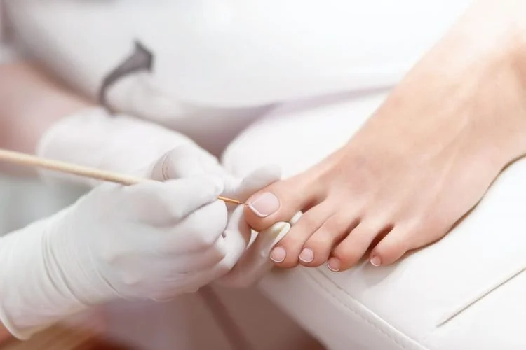 Nägel werden professionell lackiert in einem Nagelstudio.