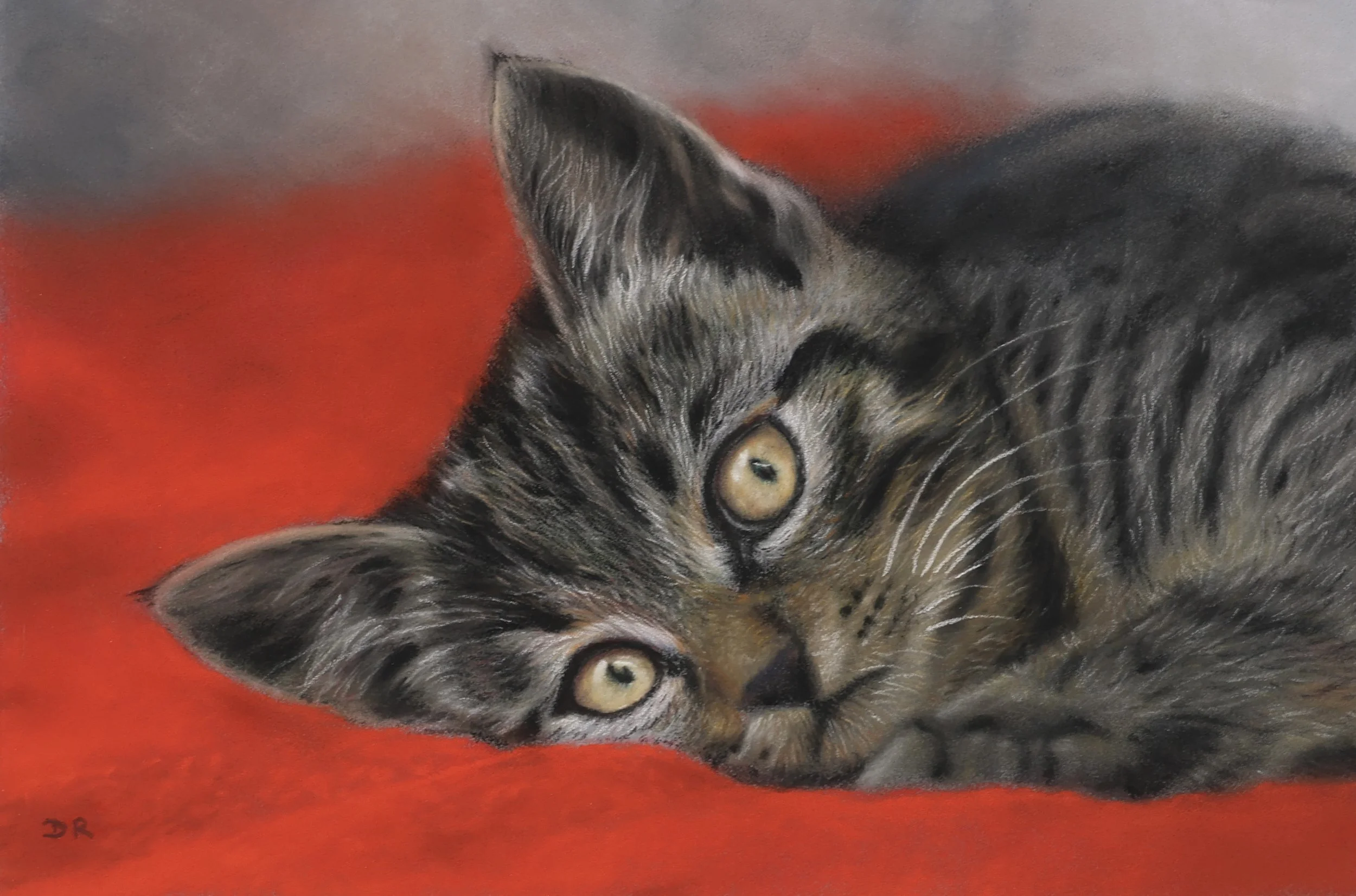 A soft pastel painting of a gray tabby kitten with yellow eyes lying on a soft red blanket. The cat meets the viewer’s eyes and the artwork emphasizes the details of the cat's fur and face.