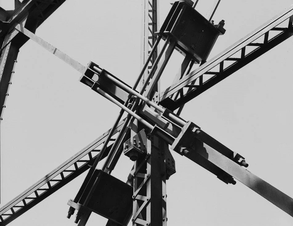 Close-up view of steel crane structure and trusses against open sky