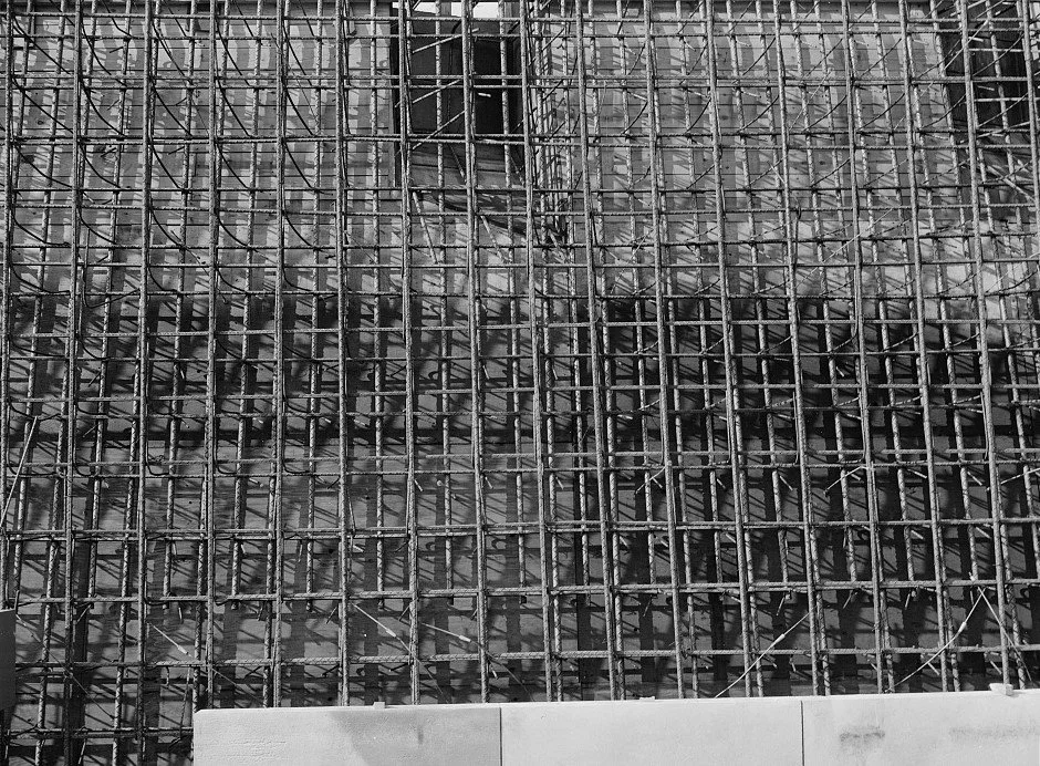 Close-up of a building under construction with a dense network of steel scaffolding.