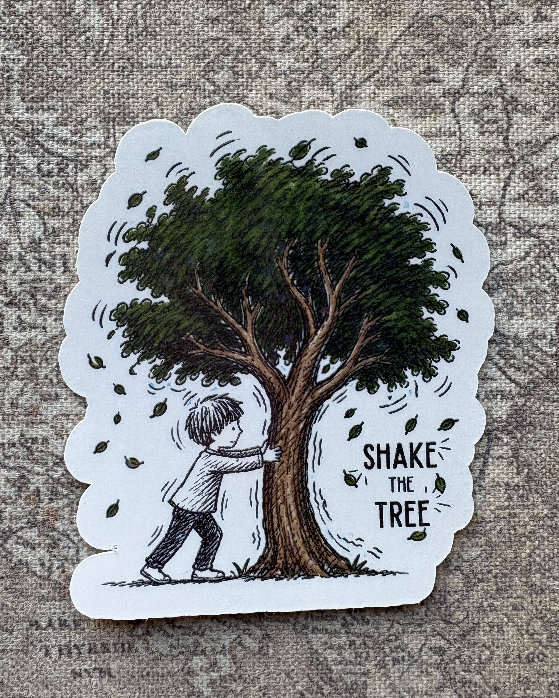 Shake the Tree sticker showing a child shaking a leafy green tree beside the words Shake the Tree.