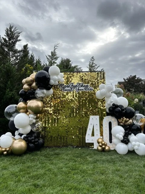 An 8 foot by 8 foot gold shimmer wall, gorgeous balloon garland and marquee numbers for an unforgettable 40th birthday party in Newtown PA 