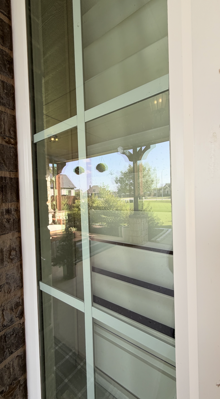 The long, tall exterior window is extremely dirty, covered in dust, dirt, pollen, and weather residue.