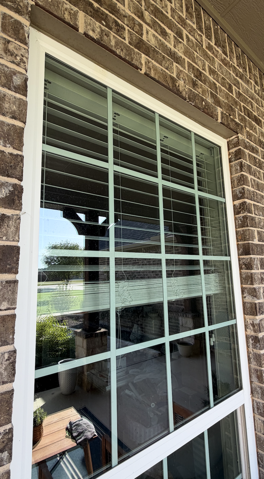Front office large standard window with pollen, dust, and mineral deposits on window pane glass.