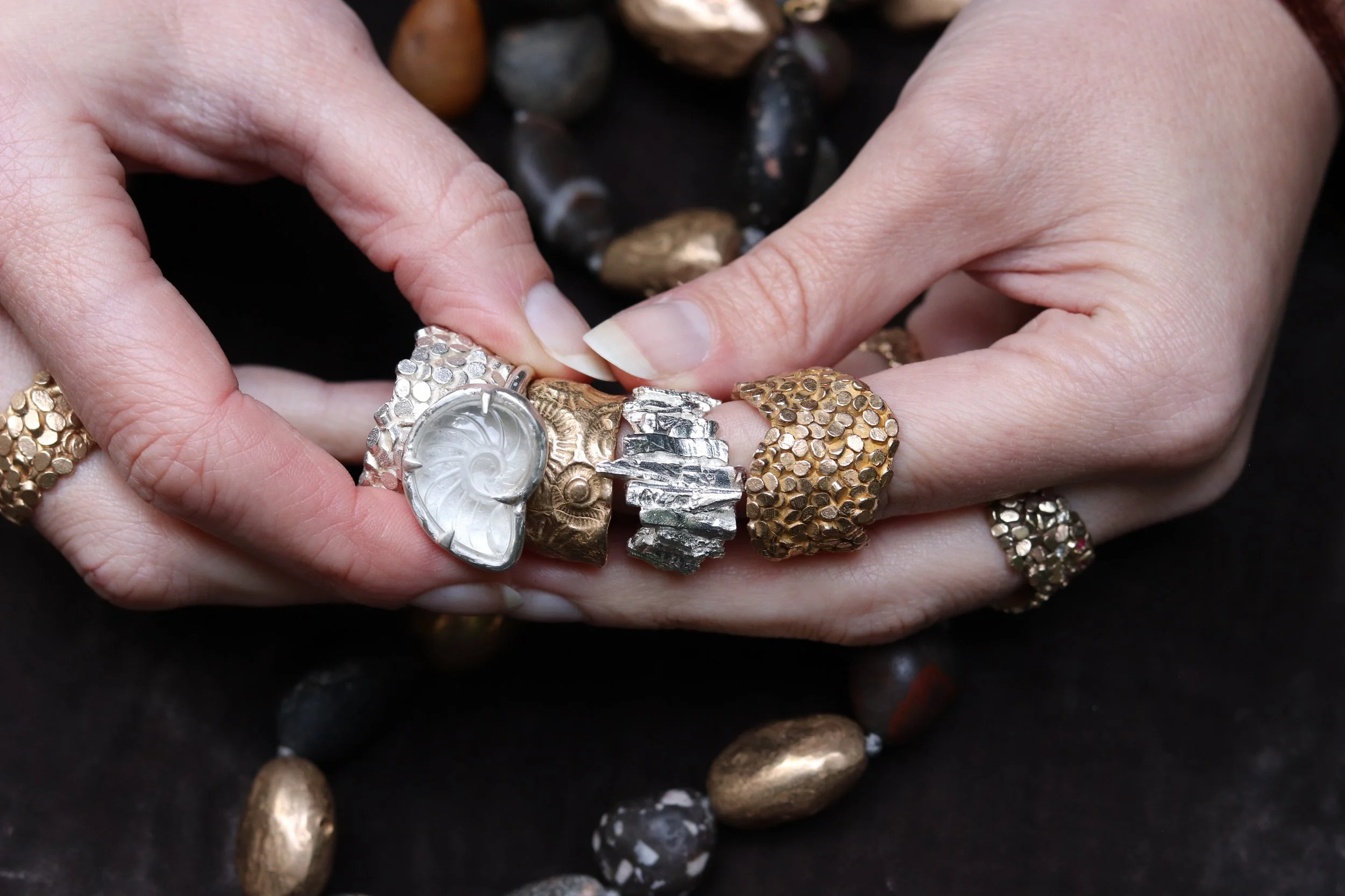 jade mellor selection of rings bronze caddis silver basalt quartz ammonite fossil ring held.JPG