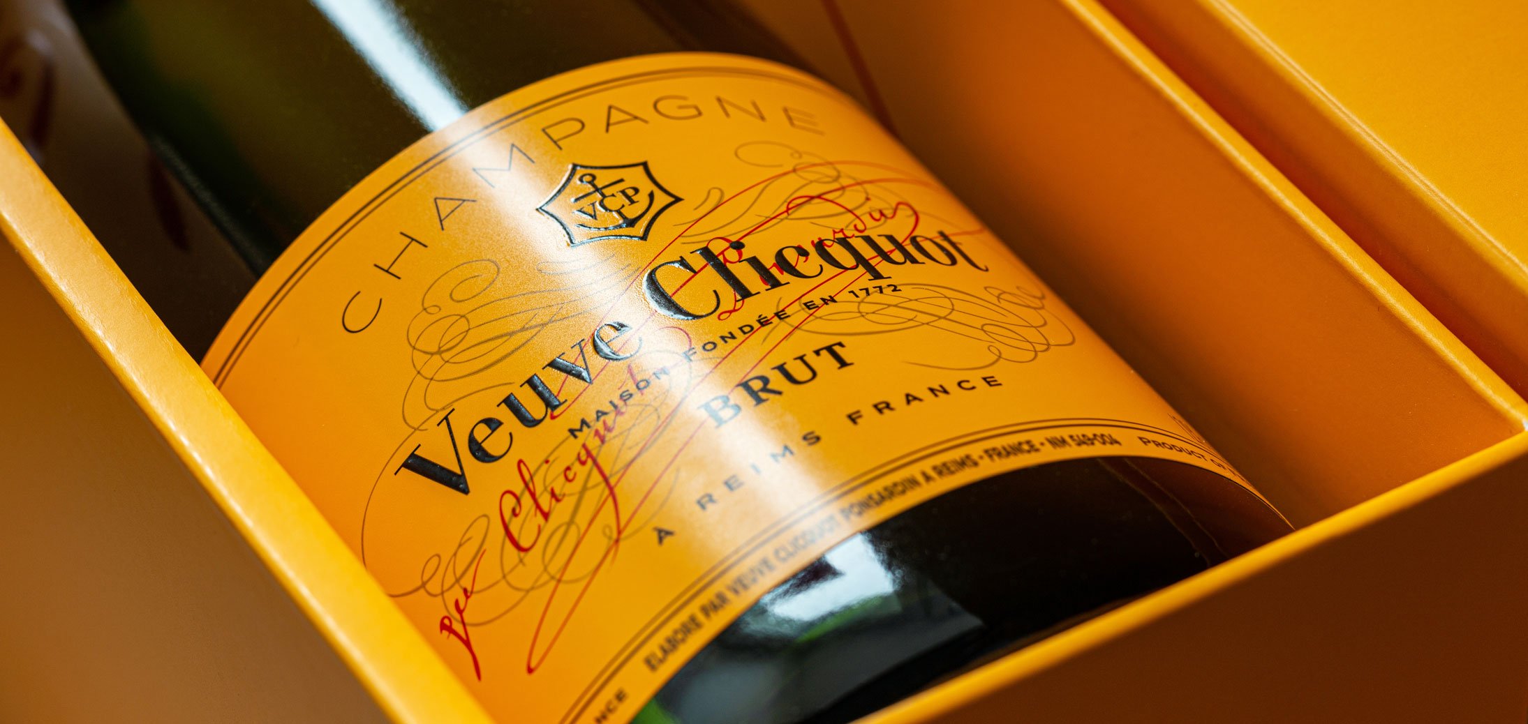 A bottle of Veuve Clicquot champagne in yellow packaging.