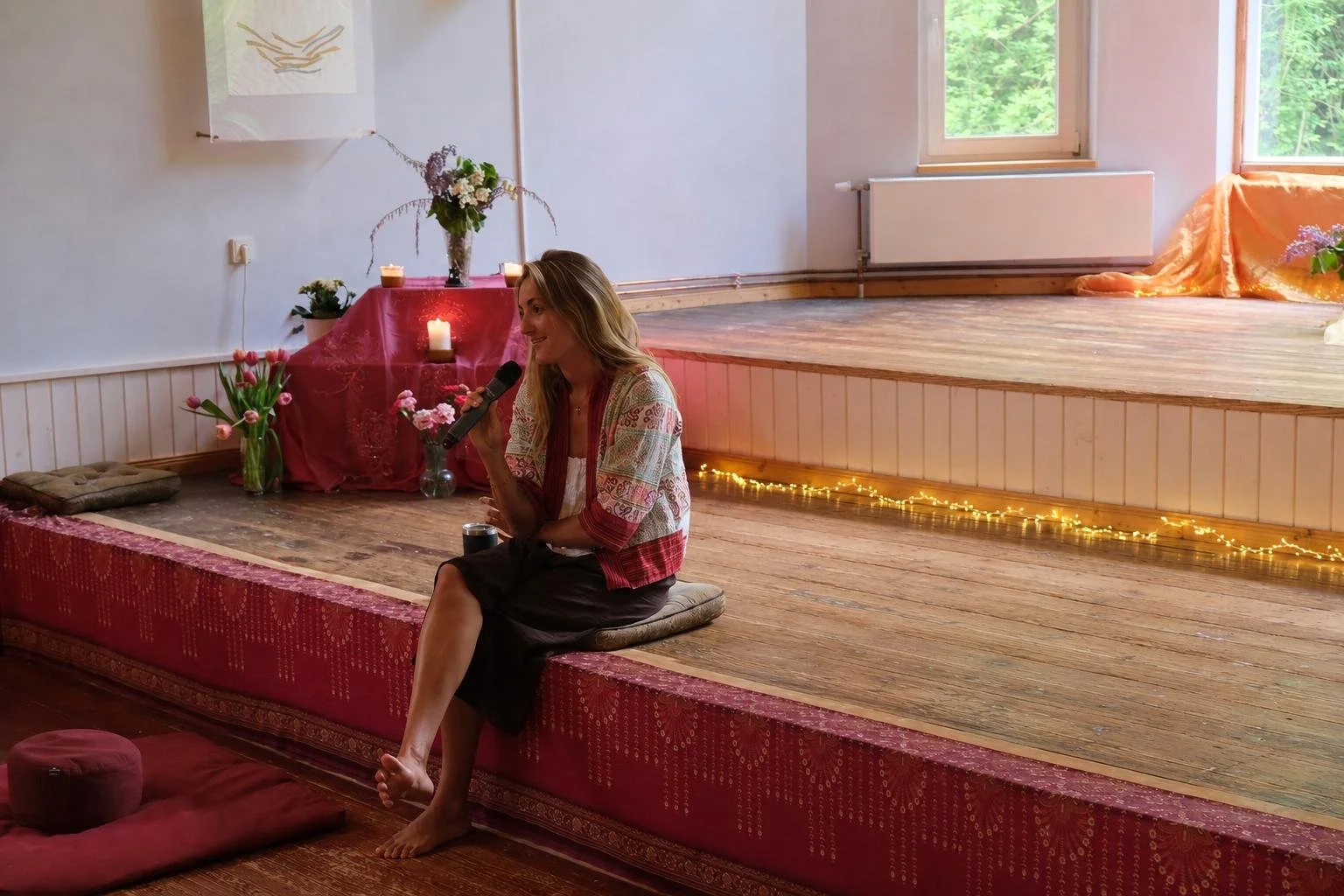 Anna teaching while seated on a stage