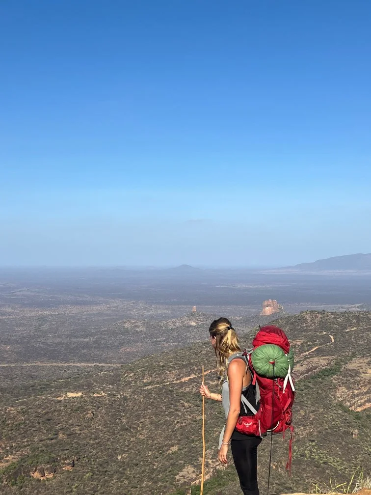 Anna Heinrichs blickt während einer Wanderung über eine weite Landschaft.